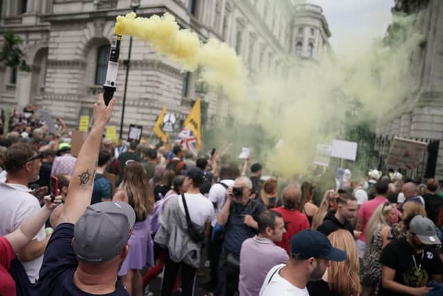 Protesters let off flares outside Downing Street during an anti-lockdown protest in central London ( PA)