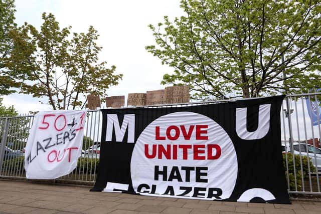 'Love United Hate Glazer' and '50+1 Glazer Out' banners are seen on a tied onto railings outside Old Trafford prior to the Premier League match between Manchester United and Liverpool at Old Trafford, which was eventually postponed.