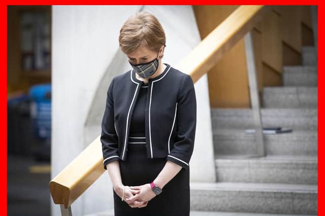 First Minister Nicola Sturgeon observes a minute's silence in the Garden Lobby of the Scottish Parliament at Holyrood, Edinburgh, during the National Day of Reflection.