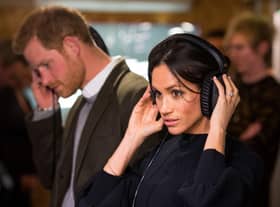 Prince Harry and  Meghan Markle listen to a broadcast through headphones during a visit to Reprezent 107.3FM community radio station in Brixton in 2018 (Photo: DOMINIC LIPINSKI/AFP via Getty Images)
