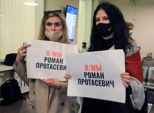 Women with posters reading 'I am/we are Roman Protasevich' in the arrival area as passengers disembark from the Ryanair passenger plane from Athens that was intercepted and diverted to Minsk on the same day by Belarus authorities on 23 May (Photo: PETRAS MALUKAS/AFP via Getty Images)