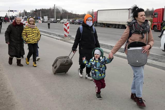 People fleeing the conflict from Ukraine, arrive at the border crossing in Medyka, southeastern Poland, on Friday, Feb. 25, 2022. U.N. officials said that 100,000 people were believed to have left their homes and estimated up to 4 million could flee if the fighting escalates.(AP Photo/Czarek Sokolowski)