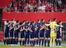 The Scotland squad stand for the national anthem prior to the clash in Vienna. Picture: SNS