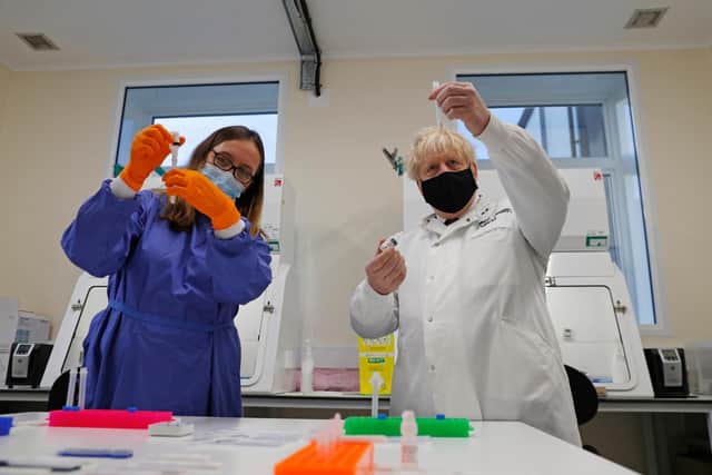 Boris Johnson (R) looks at samples at the Lateral Flow Testing Laboratory with Doctor Abbie Bown (L) during a visit to the Public Health England site at Porton Down science park on November 27, 2020 (Adrian Dennis - WPA Pool / Getty)
