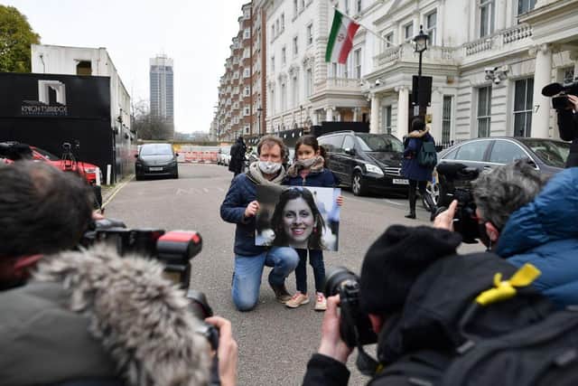 Richard Ratcliffe, husband of British-Iranian aid worker Nazanin Zaghari-Ratcliffe jailed in Tehran since 2016, and his daughter Gabriella, hold a picture of Nazanin as they protest outside of the Iranian Embassy in London on March 8, 2021 (Photo by BEN STANSALL/AFP via Getty Images)