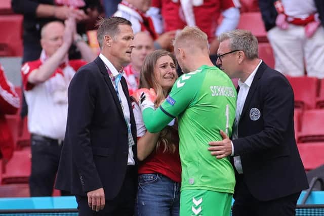 Denmark's goalkeeper Kasper Schmeichel comforts Sabrina Kvist Jensen, partner of Denmark's midfielder Christian Eriksen, after he collapsed on the pitch.