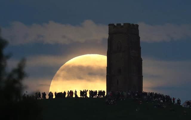The full moon could appear similar in size and colour to this one, which revellers gathered to witness in Glastonbury in 2016 (Picture: Getty Images)